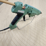 Knoestvuller aanbrengen met verwarmd pistool op eikenhouten tafel